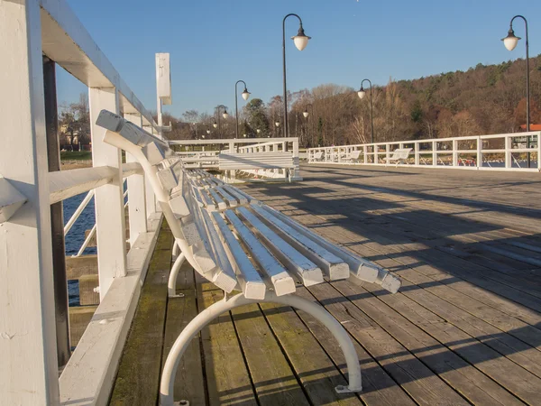 White benches standing on the pier at the Baltic sea — Stock Photo, Image