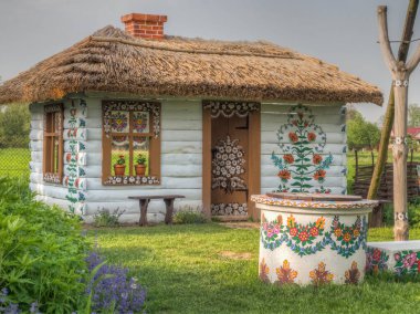 Zalipie, Polonya - 20 Mayıs 2017: Duvarlarında çiçekler ve Malopolska 'nın Zalipie köyünde güneş saati bulunan renkli ev