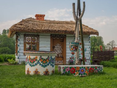 Zalipie, Polonya - 20 Mayıs 2017: Duvarlarında çiçekler ve Malopolska 'nın Zalipie köyünde güneş saati bulunan renkli ev