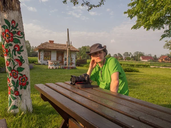 Sedí Stolu Kamerou Pozadí Barevný Dům Vesnici Zalipie — Stock fotografie