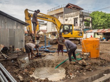 Ambon, Endonezya - 17 Şubat 2018: Ambon caddesinde su pompalayan işçiler.