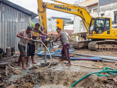 Ambon, Endonezya - 17 Şubat 2018: Ambon caddesinde su pompalayan işçiler.
