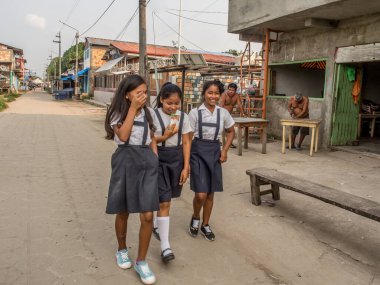 Santa Rosa, Peru - 18 Şubat 2017: Okuldaki çocuklar küçük Peru köyünün sokaklarında yürürken üniforma giyiyorlar.