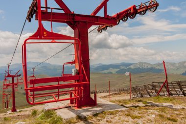 Kullanılmayan teleferik kırmızı koltukları.