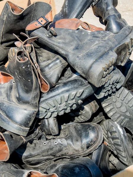 Un montón de viejas botas militares desgastadas de cuero — Foto de Stock