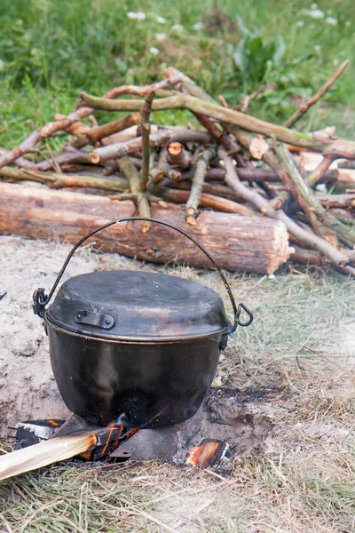 Cooking a meal on a campfire in metal vessels — Stock Photo, Image