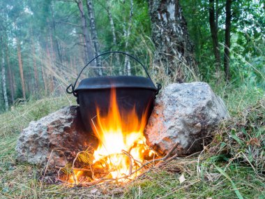 bir kamp ateşi metal damarları üzerinde bir yemek pişirme