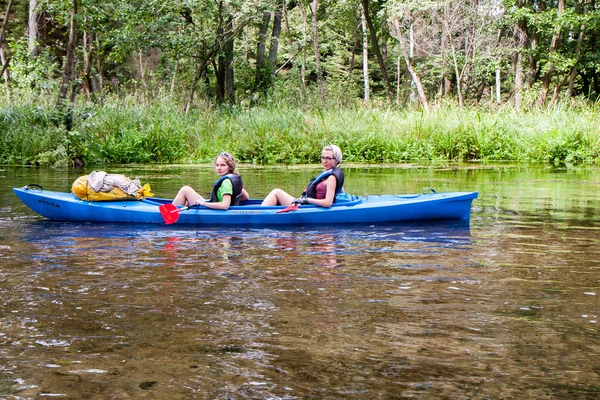 Wo chicas jóvenes con chalecos salvavidas y sentado en un kayak . — Foto de Stock