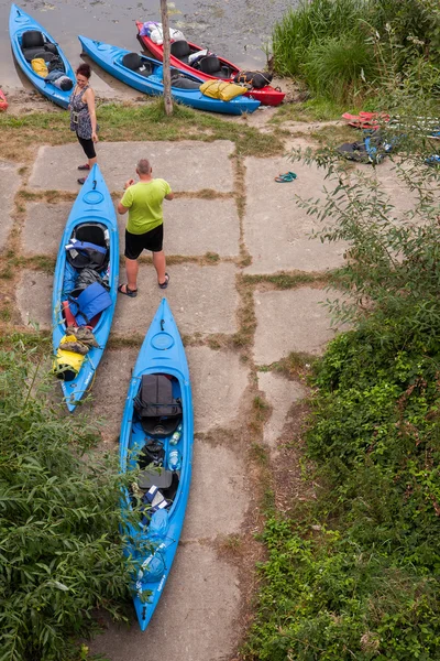 The Group of kayaks flowing down the river between overturned trees — Stock Photo, Image
