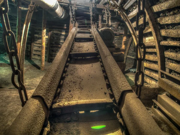 Uma mina de carvão. Transportador trabalhando em um túnel de mina . — Fotografia de Stock