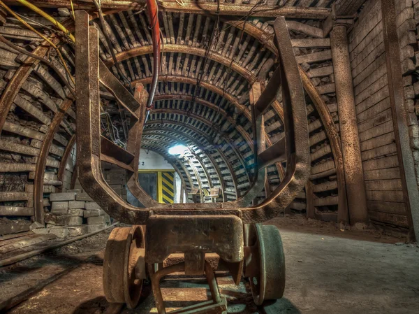 Een oude en verwoeste wagen voor het vervoer van steenkool in een kolen mijn tunnel. — Stockfoto