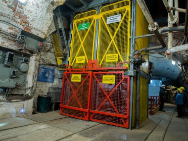  İnsanlar benim bekleyen bir asansör boşluğunda kömür için kask giyen