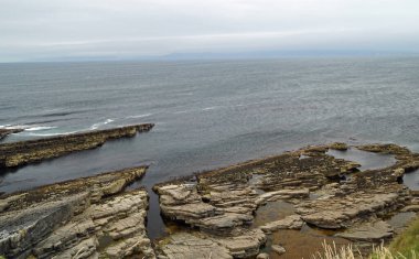Mullaghmore Head 'e giderken, Mullaghmore' un güzel kumsal ve rıhtımının yanından geçiyorsun. Kasabadan hemen sonra, dalgalar sakin kıyı şeridine doğru ilerliyor..
