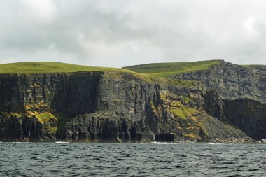 Vahşi Atlantik Yolu - Moher Kayalıklarında tekne gezisi. Moher Kayalıkları İrlanda 'nın en bilinen kayalıklarıdır. İrlanda 'nın ana adası olan Clare' in güneybatı kıyısında Doolin ve Liscannor köylerinin yakınında yer almaktadır..