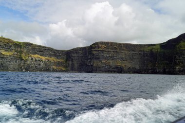 Vahşi Atlantik Yolu - Moher Kayalıklarında tekne gezisi. Moher Kayalıkları İrlanda 'nın en bilinen kayalıklarıdır. İrlanda 'nın ana adası olan Clare' in güneybatı kıyısında Doolin ve Liscannor köylerinin yakınında yer almaktadır..