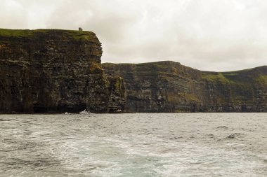 Vahşi Atlantik Yolu - Moher Kayalıklarında tekne gezisi. Moher Kayalıkları İrlanda 'nın en bilinen kayalıklarıdır. İrlanda 'nın ana adası olan Clare' in güneybatı kıyısında Doolin ve Liscannor köylerinin yakınında yer almaktadır..