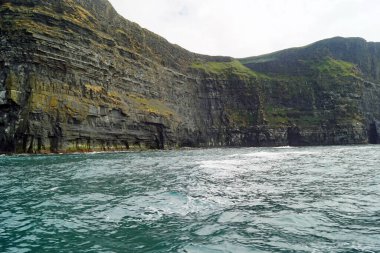 Vahşi Atlantik Yolu - Moher Kayalıklarında tekne gezisi. Moher Kayalıkları İrlanda 'nın en bilinen kayalıklarıdır. İrlanda 'nın ana adası olan Clare' in güneybatı kıyısında Doolin ve Liscannor köylerinin yakınında yer almaktadır..