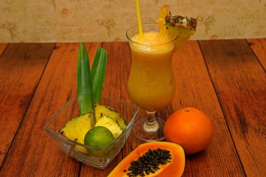 Ananas limonlu papaya portakallı tropik alkolsüz kokteyl. Alkolsüz renkli kokteyller bardaklara dizilmiştir.