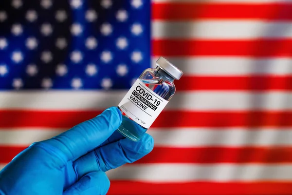背景是Covid 19疫苗瓶和美国国旗 美国用于预防头孢病毒疫苗接种的小瓶疫苗 — 图库照片