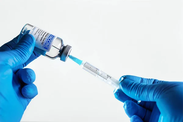 为预防白种人感染 在注射器中注射通用疫苗 为全球疾病疫苗接种计划准备免费疫苗瓶的医生 — 图库照片