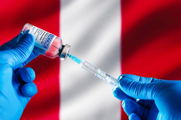 Doctor preparing vial of vaccine injection for the vaccination plan against diseases in Peru. Injecting dose of vaccine in syringe for infections prevention in front of the Peru flag