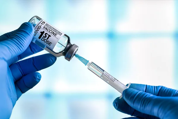 医師コロナウイルスワクチンボトルラベルにワクチンの最初の用量の名前を持つ 医者はCovid 19のための最初のワクチンの患者のための線量を準備する — ストック写真