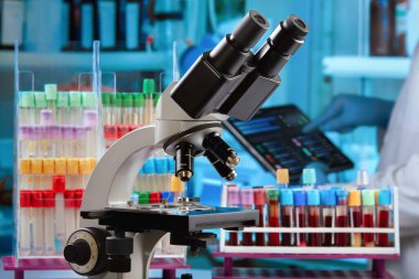 Bir kan bankasındaki kan tüplerinin verilerini analiz eden hematolog. Laboratuvarda kan örnekleri, mikroskop ve sonuçlar analiziyle çalışan bir araştırmacı.