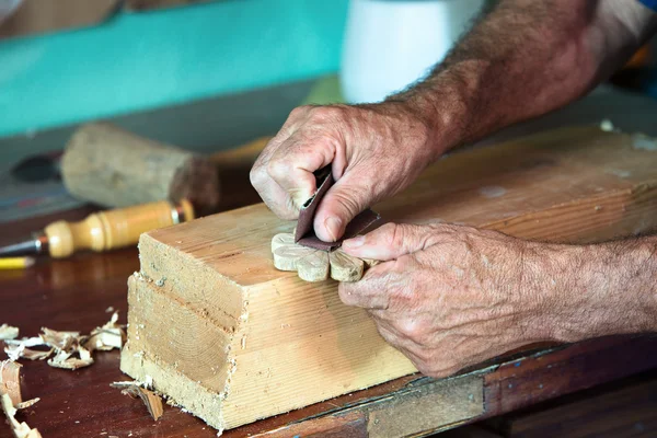 Handen van een schrijnwerker schuren een stuk hout — Stockfoto