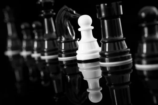 White pawn among black chess — Stock Photo, Image