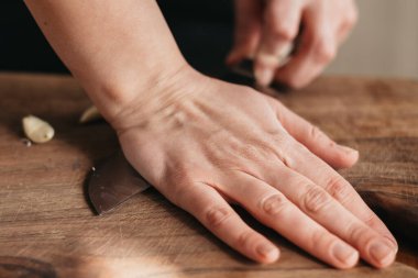 Sarımsağı ahşap bir tahtada ezerken yakın çekim.