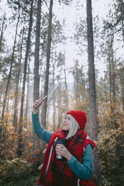 女背包客带着自己的手机在森林里 — 图库照片