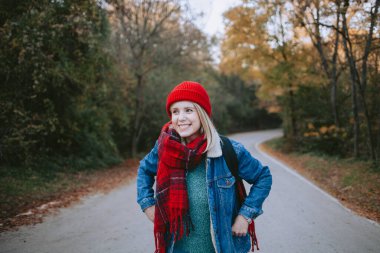 Sonbaharda dağ yolunda yürüyen bir kadın gezgin.