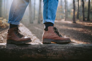 Ormanda düşmüş bir kütükte yürüyen bir kadın.