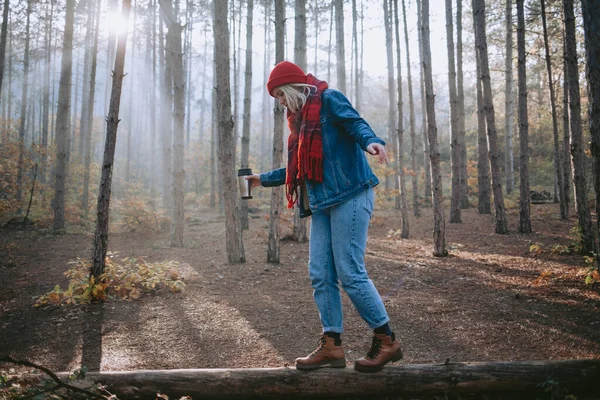 在森林里踩着倒下的圆木走路的女人 — 图库照片