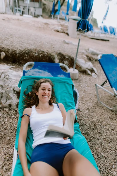 女人在海滩上晒日光浴和看书 — 图库照片