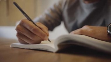 Masaya defter çizen bir adam.