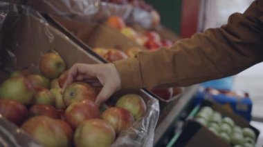 Çiftçi pazarında elma seçen bir adam