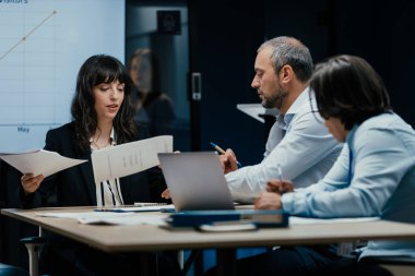Kafkasyalı gevşek yöneticiler ve resmi giyinmiş ortaklar modern yapay ofisteki büyük ekranda ilerleme raporunu tartışıyorlar, işbirlikçi iş beyin fırtınası oturumu