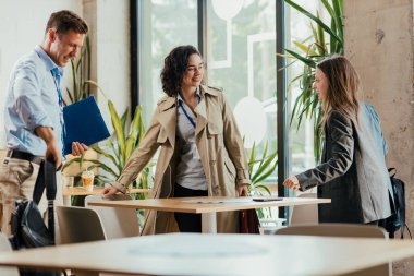 Heyecanlı iş arkadaşları, saha yarışmasını kazandıktan sonra konferans salonunda buluştular. Takım başarılı sunumunu kahve ve içeceklerle kutluyor. Etkinlik sonrası ağ kurma ve zafer kutlama anı.