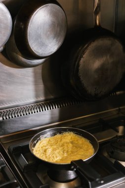 Profesyonel bir mutfak sobasında çırpılmış yumurta pişirme.