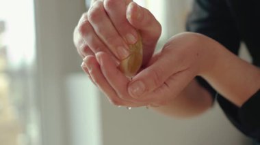 Kadın şefin elleri yavaş çekimde içindeki malzemelerle taze limon suyunu bir kaseye sıkıyor.