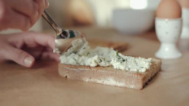 Kahvaltıda bir dilim çavdar ekmeğine otla süzme peynir döken birine yaklaş.