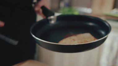 Lezzetli bir kahvaltı hazırlamak için sıcak tavada ekmek kızartan profesyonel aşçı.