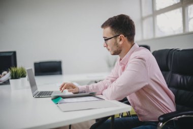 Genç adam ofiste bir proje üzerinde çalışıyor.