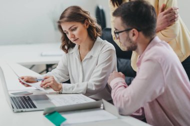 İş ekibi ofiste bir proje üzerinde çalışıyor.