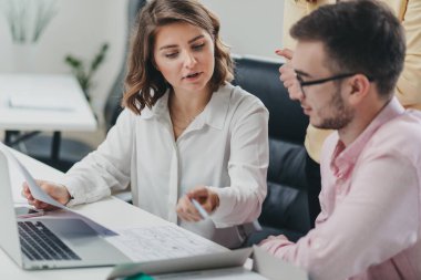 İş ekibi ofiste bir proje üzerinde çalışıyor.