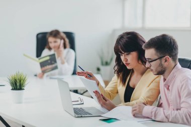 İş ekibi ofiste bir proje üzerinde çalışıyor.