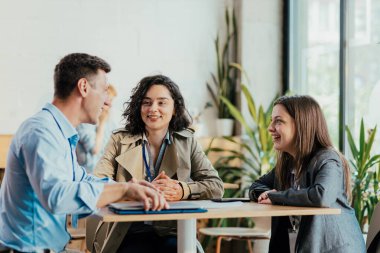 Masadaki sıradan bir ofis molası sırasında çeşitli iş adamları tartışıyor.