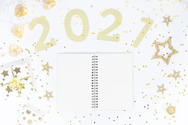 Notebook with pen on white table with numbers 2021