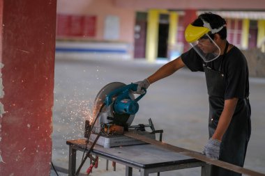 Muadzam Şah, Malezya - 14 Ekim 2020: Metal plaka için disk kesici kullanan genç adam, endüstriyel ve inşaat araçları.